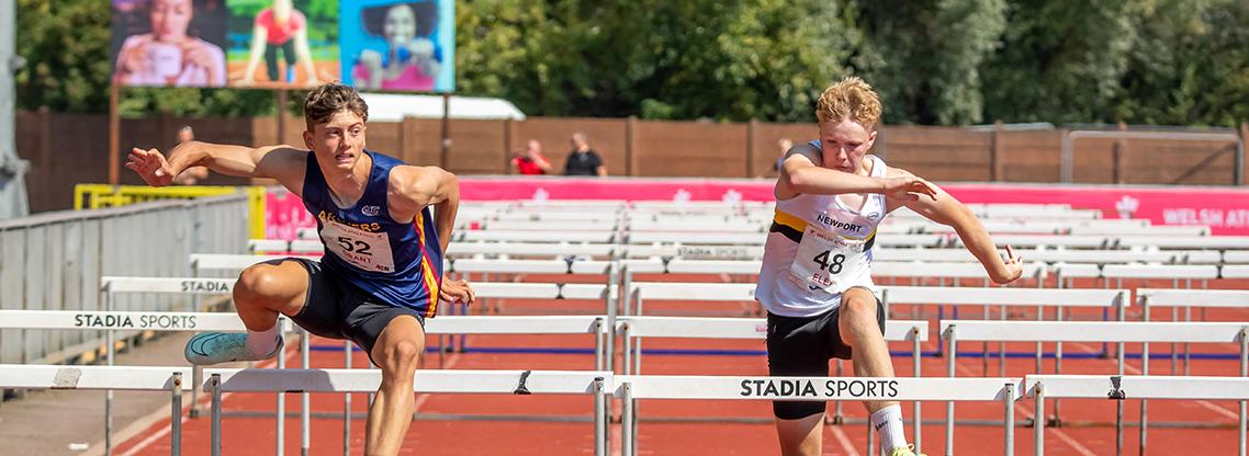 Junior boys athletes competing in the hurdles.