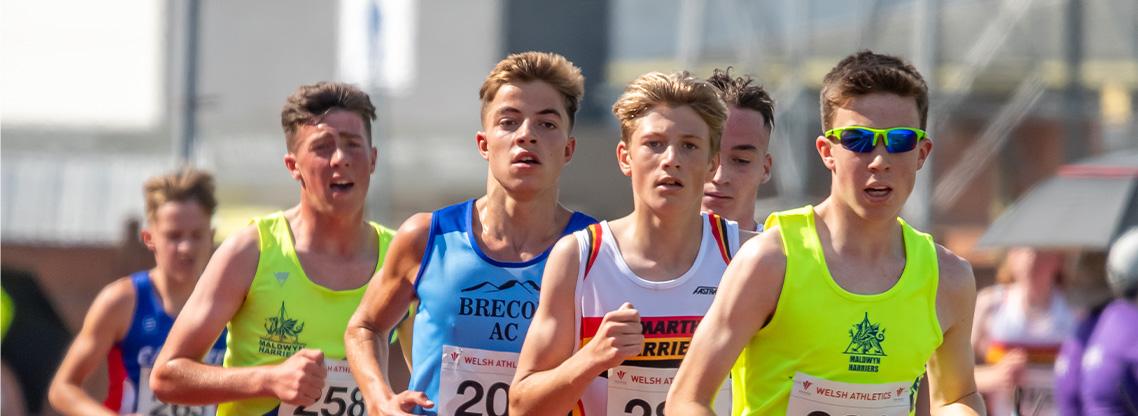 Junior boy athletes running.