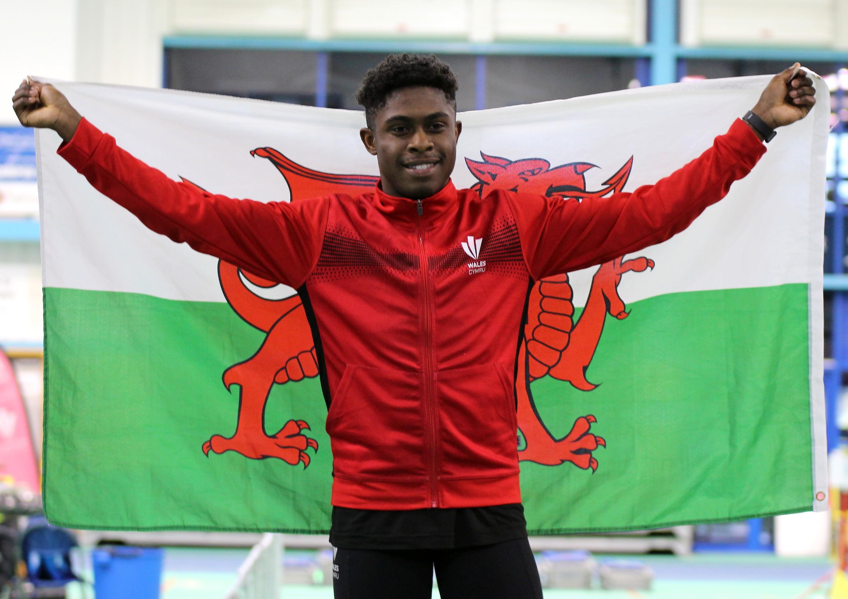Jeremiah Azu celebrates on the  podium with the Welsh flag..jpg